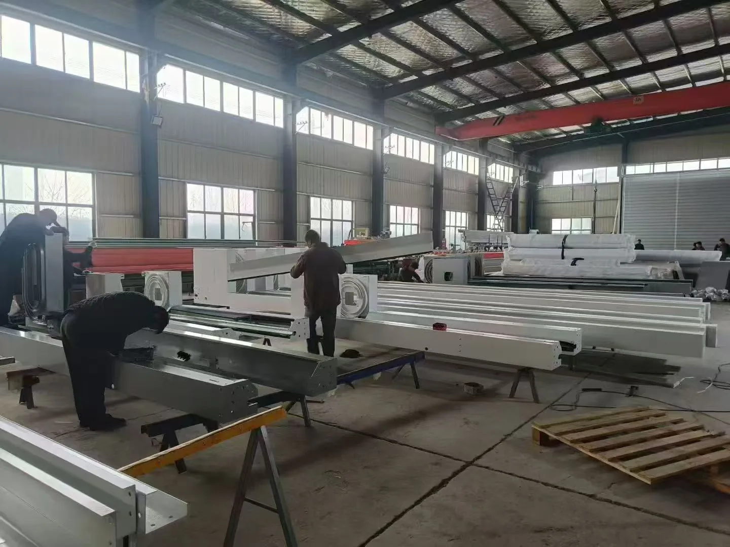 Workers manufacturing rolling shutter door frames in the factory